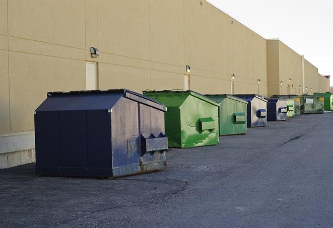 a series of colorful, utilitarian dumpsters deployed in a construction site in Florida City